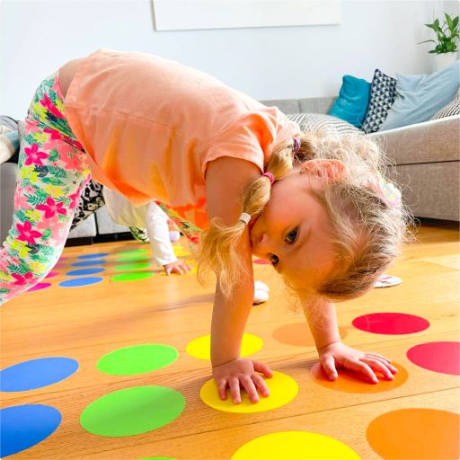 dziecko grające w twistera w gre kolorowe podłogowe kropki